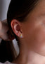 Nærbilde av en sideprofil på en kvinne i ført en gull øredobb med lavendel stener.