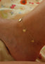 Nærbilde av Sunflower Anklet i gull. Små delikate solsikker henger rundt ankelkjedet og gir et rolig og sommerlig uttrykk.
