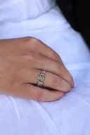 Nærbilde av en hånd med melodie sølvring med oliven krystall.