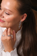 Nærbilde av en kvinne med Daisy Flower øredobber i sølv med hvite cubic zirconia stener.