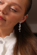 Nærbilde av en kvinne med Daisy Flower Earrings i sølv med hvite cubic zirconia stener.