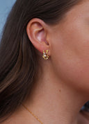 Sideprofil av en kvinne utsmykket med elegante gulløredobber med champagne stener.