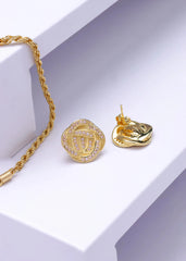 Forever knot med champagne stener på en hvit flate med et armbånd som komplementerer øredobbene til venstre. 
