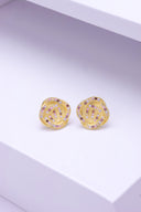 Delikate og stilfulle knute øredobber i multifarget rosa, lavendel og rhodolite cubic zirconia steiner. Diamantene ligger elegant langs kantene som former knuten. Øredobbene glitrer der de ligger pent på en hvit, minimalistisk overflate.