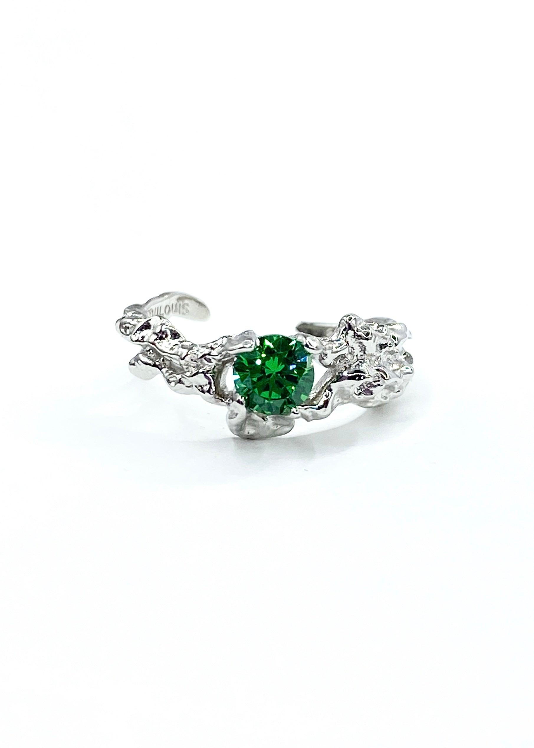 Vakker sølvring med smaragd grønn sten på en elegant hvit bakgrunn.
