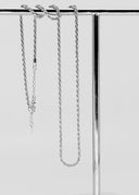 Sølvtwist-kjede elegant vist på en blank smykkestang med reflekterende overflate.