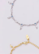 Ett sølv og gull armbånd på en hvit bakgrunn.