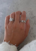 En delikat hånd med vakre sølvsmykker med hvite stener. 