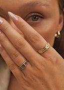 En kvinne holder hånden pent under øyet. På hånden har hun Katharina ringen og StarWave ringen i gull.