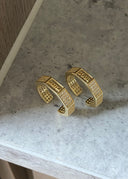 Soul og Sister ringene i gull ligger på en grå marmor overflate. Ringene står oppreist, graveringen av Soul og Sister er tydelig fremmet.