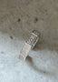 Nærbilde av soul ringen i sølv. Ringen er formet som et hexagon, på sidene er det glitrende hvite cubiz zirconia mens på fremsiden er det gravert SOUL. Ringen har en åpning på baksiden da den er justerbar.