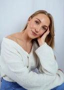 Bilde av en kvinne med lyst hår og lys hudtone. Hun har på seg en hvit strikkegenser og blå silke bukse. I øret har hun Dome hoops i sølv, og en sølvring på hånden.