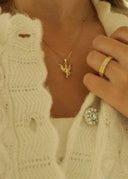 Nærbilde av halsen til en kvinne som har på seg Fairy halskjede i gull.