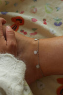 Nærbilde av en kvinne sin ankel med Sunflower Ankelkjede i sølv.