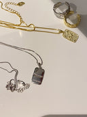 Gull og sølvsmykker som ligger delikat plassert ved baderomsvasken..