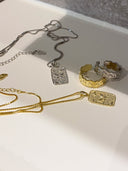 Gull og sølvsmykker ligger på baderomsbenken. 