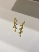 Nærbilde av Daisy Flower øredobber i blå som ligger på baderomsvasken.