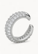 En pave earcuff med hvite glitrende cubic zirconia stener. Bilde er tatt på en hvit og minimalistisk bakgrunn.